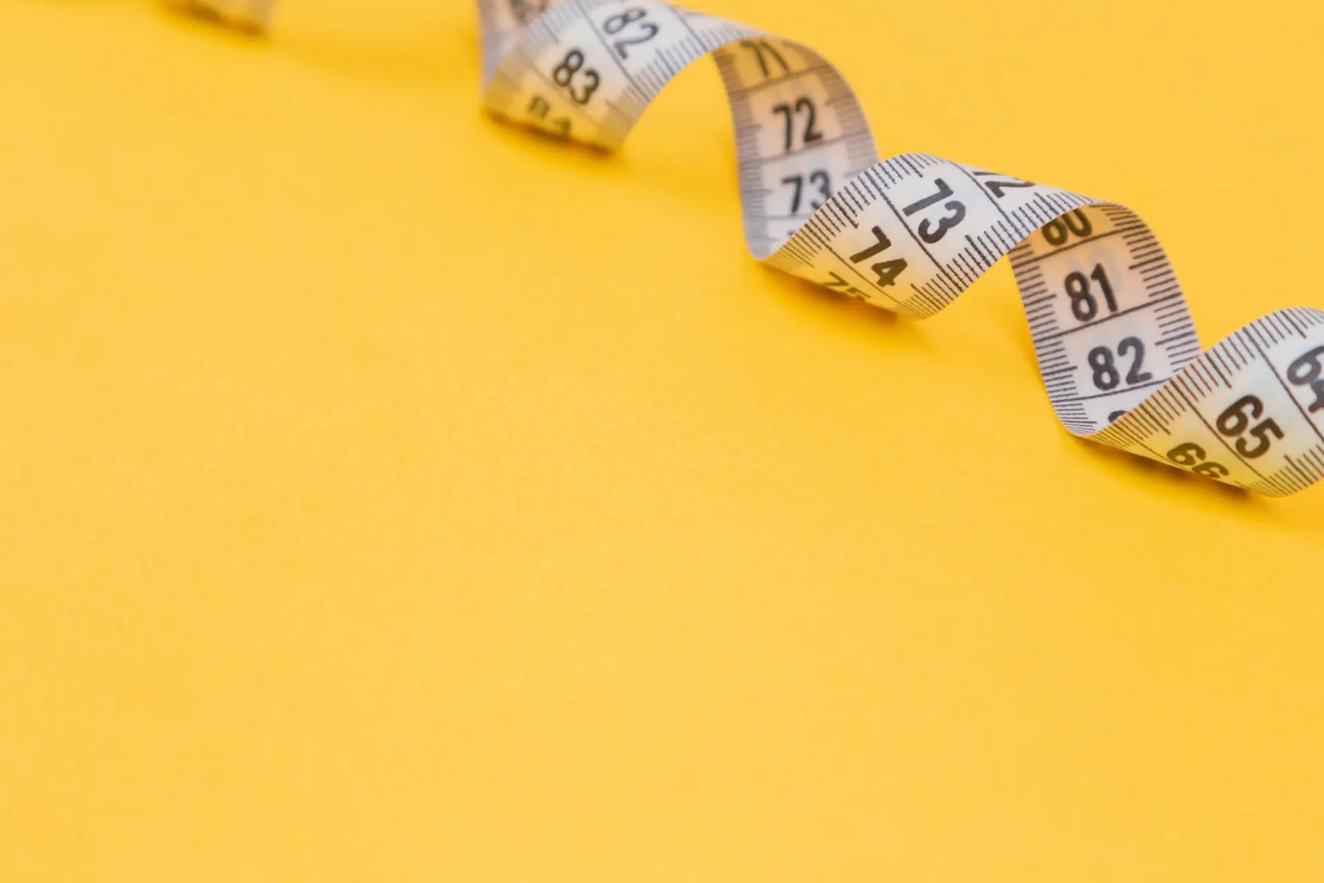white tape measure on yellow surface